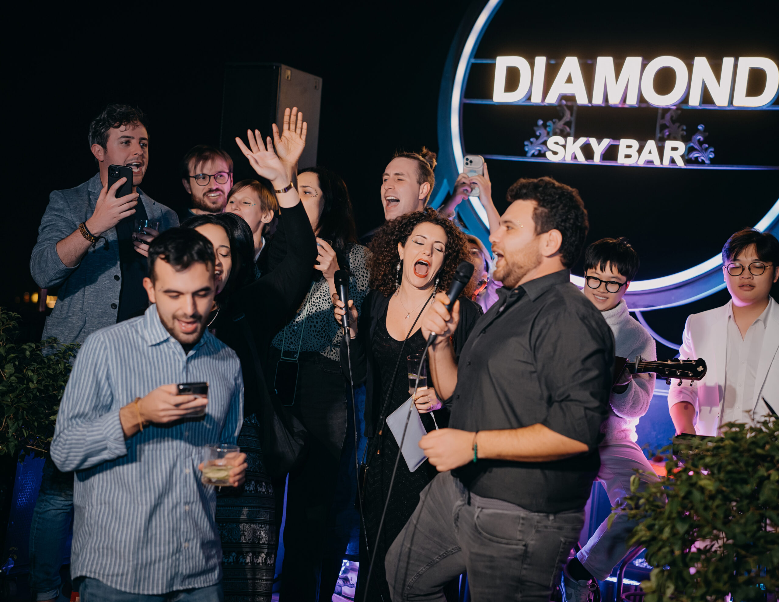 Evening ambiance at Diamond Sky Bar Hanoi with guests enjoying live music and rooftop lights